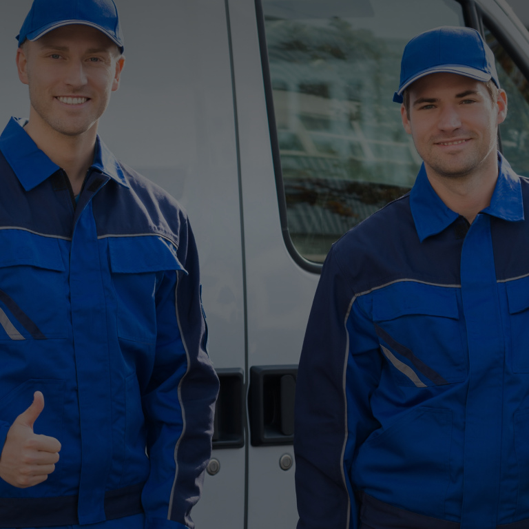 Two men smiling in front of van